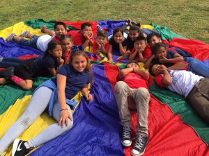 Children playing with a big multicolor parachute