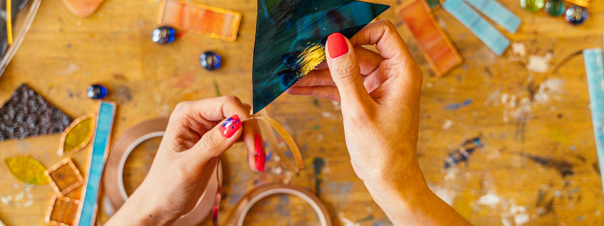 female hand making colorful artwork above table