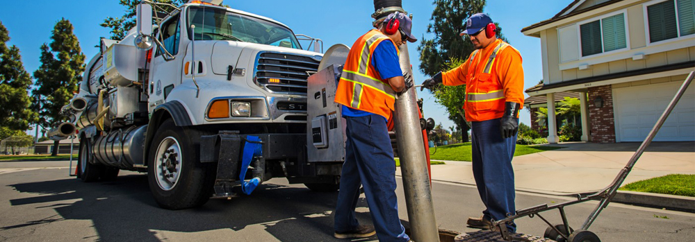 Two publics works employees servicing a sewer line