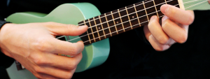 person playing teal ukulele