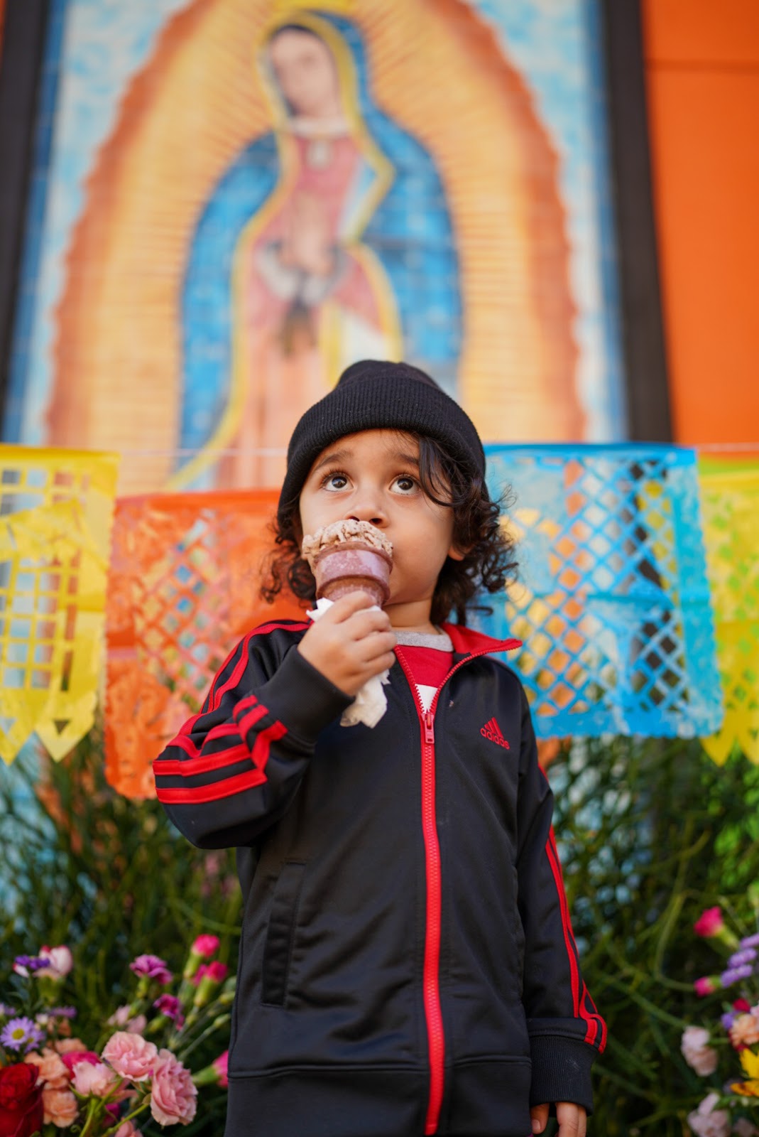 Kid eating ice cream in front of Virgin Mary mural in Downtown Santa Ana