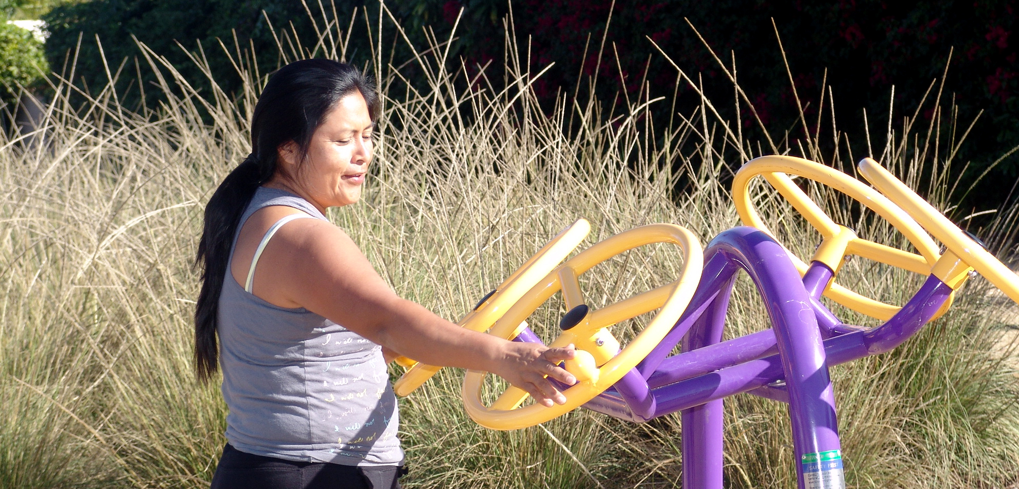 resident using the exercise equipment at maple-occidental exercise park