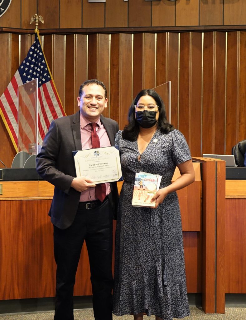 Councilmember Lopez Recognizing Author Ernesto Cisneros at the dais