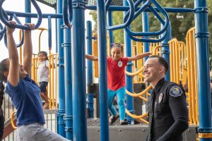 Police Officer With Children At Park Playground