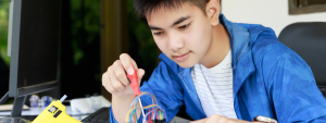 teen boy working on a circuit with a screwdriver