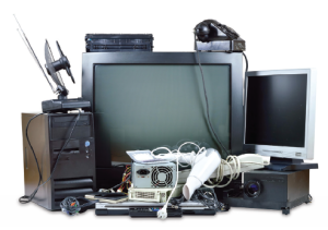 A pile of old electronic devices including a television, a computer, a monitor and cables.