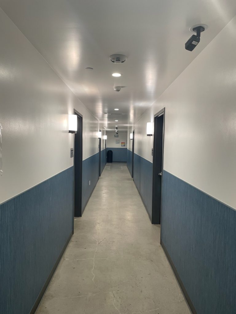 Photo of corridors with blue wallpaper along the lower half.