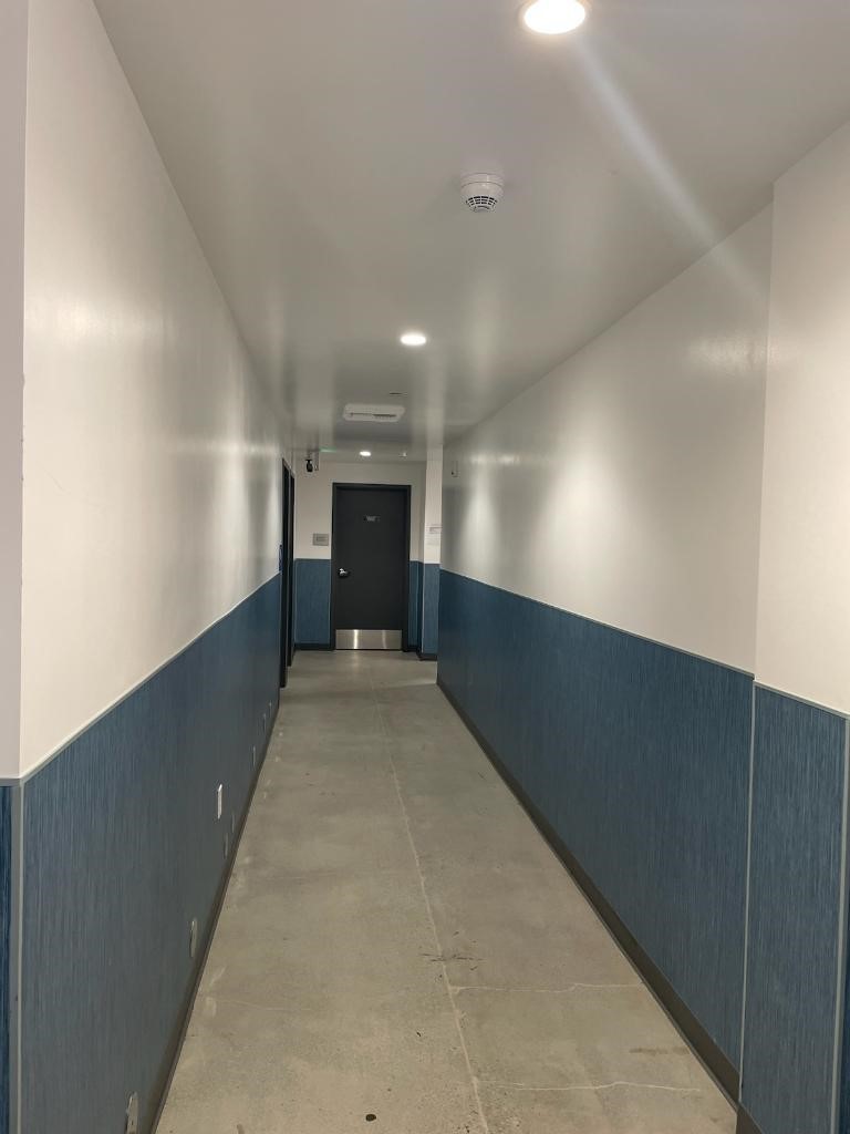 Photo of corridors with blue wallpaper along the lower half.