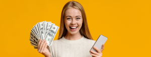 lady smiling holding money and a phone