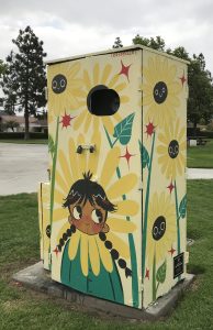 Utility box with art of sunflowers and a child