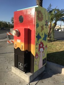 Utility box with art of mushrooms, butterflies, and the sun
