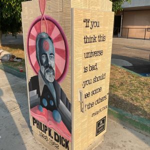 Utility box with art of an artist man amongst many of his pages and quotes