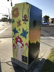 Utility box with art of butterflies, mushrooms, and the sun