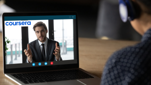 man on headphones in front of laptop with person and coursea words