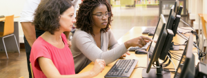 One lady helping another on a pc