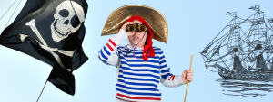 kid dresses as pirate looking through binocalurs next to pirate flag and ship