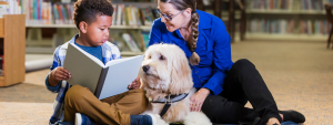 parent and child reading to a dog