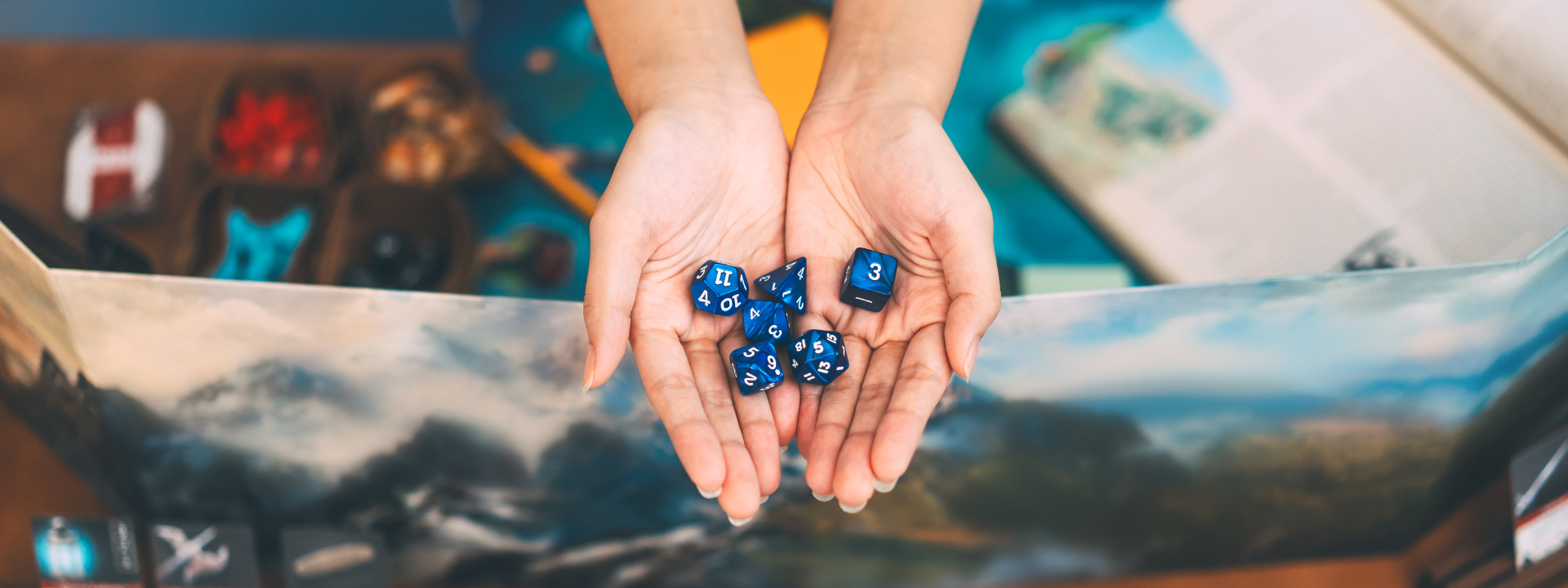 hands holding dice over play mat