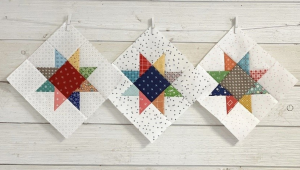 paper quilts with colorful stars in the middle hanging off wall