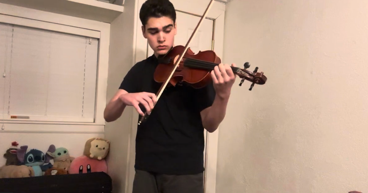 A young man playing a viola.