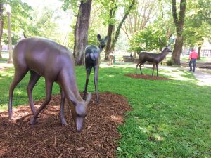 Bronze sculptures of deer on a lawn