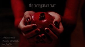 A screenshot of a hands holding a pomegranate.