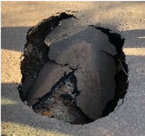sinkhole in a pedestrian pathway over the drainage channel on First Street West