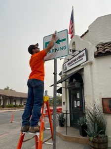 City Public Works Staff Installing a New Directional Parking Sign on the Plaza.