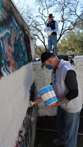 Wayne Schake and Gary Edwards painting over graffiti at Mountain Cemetery