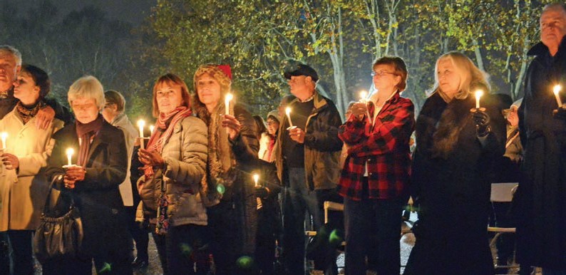 Group of people gathered with lit candles.