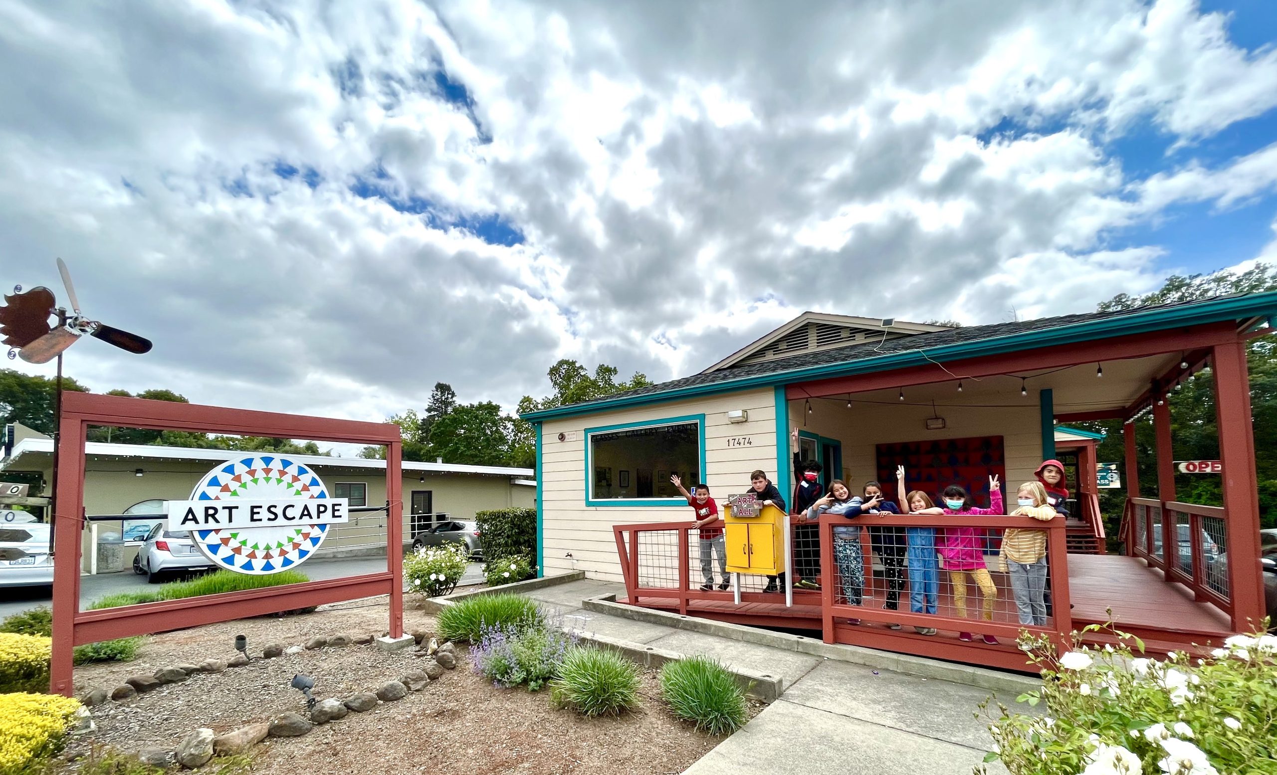 Photo of children waving outside of Art Escape building