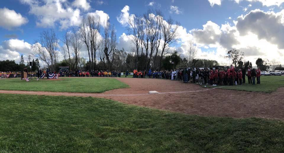 Baseball field surrounded by youth baseball players.