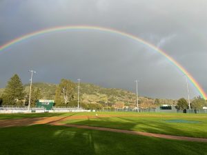 Photo of baseball field and football field with rainbow.