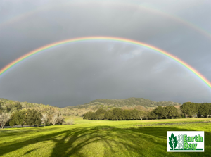 Photo of field with double rainbow in the sky.