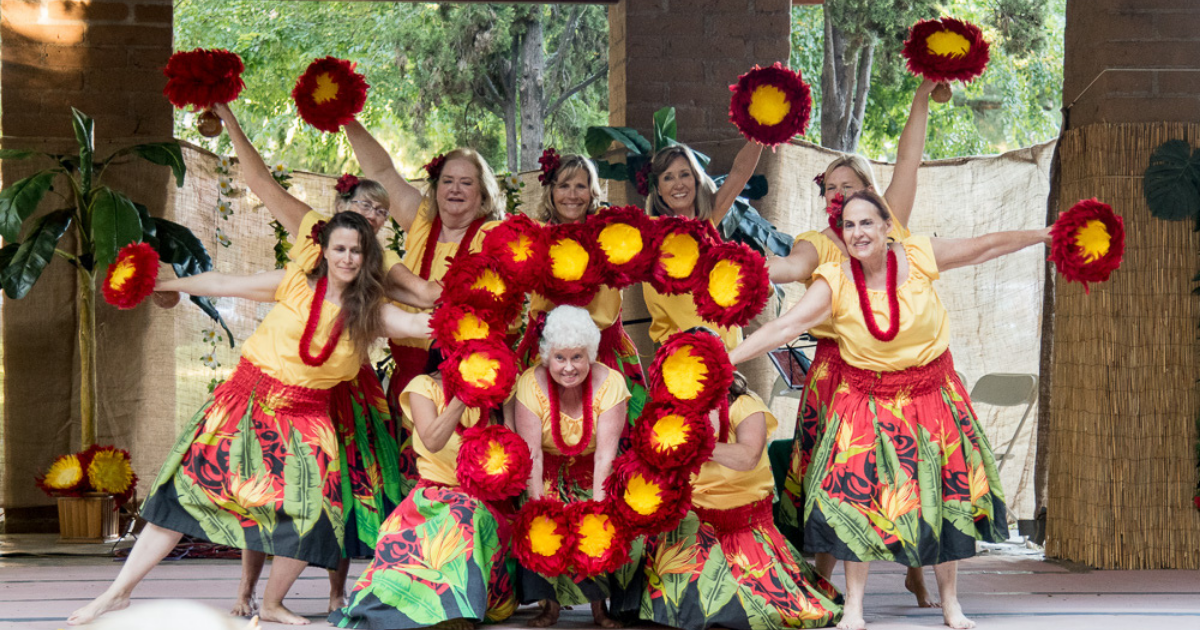 Hula dancers in colorful costumes posing during a performance.