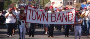 Band wearing red and white with a sign that reads "Town Band."