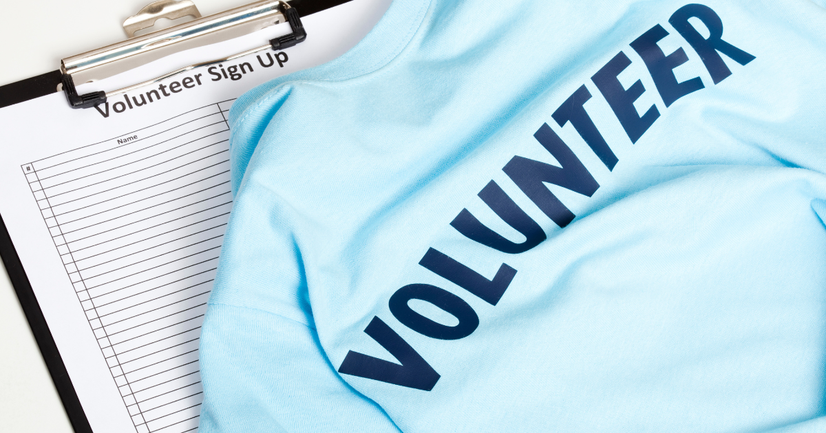 Clipboard with sign up sheet and tee shirt that says 'Volunteer'