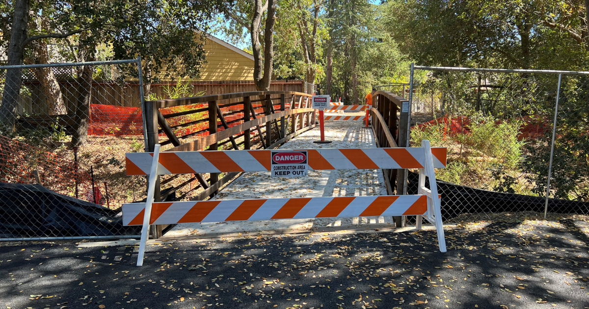 A bridge with barriers and caution signs blocking passage.