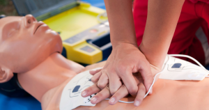 A person practicing hand compressions on the chest of a mannequin.