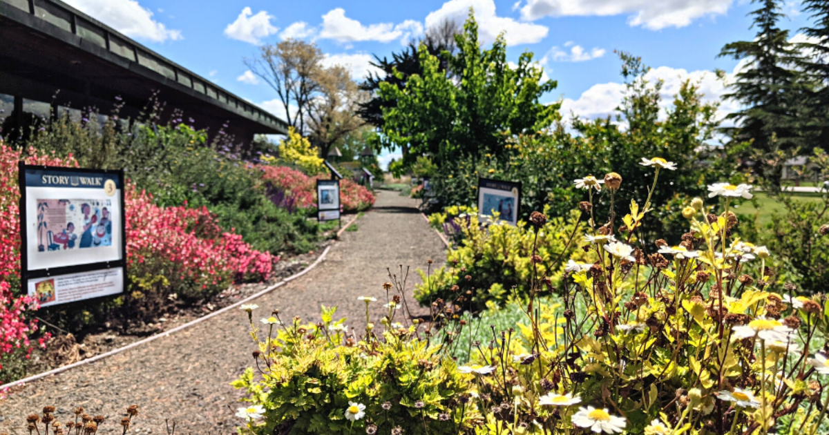 Photo of garden with walking path, flowers and informational signage.