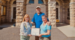 Mayor Sandra Lowe presents a certificate to Sheana Davis and Ben Sessions of The Epicurean Connection in front of City Hall on May 21, 2023.