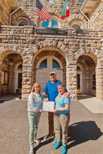 Mayor Sandra Lowe presents a certificate to Sheana Davis and Ben Sessions of The Epicurean Connection in front of City Hall on May 21, 2023.