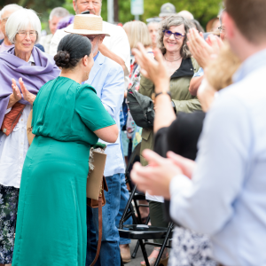 US Poet Laureate Ada Limon recieving applause by a crowd at a bench dedication ceremony.