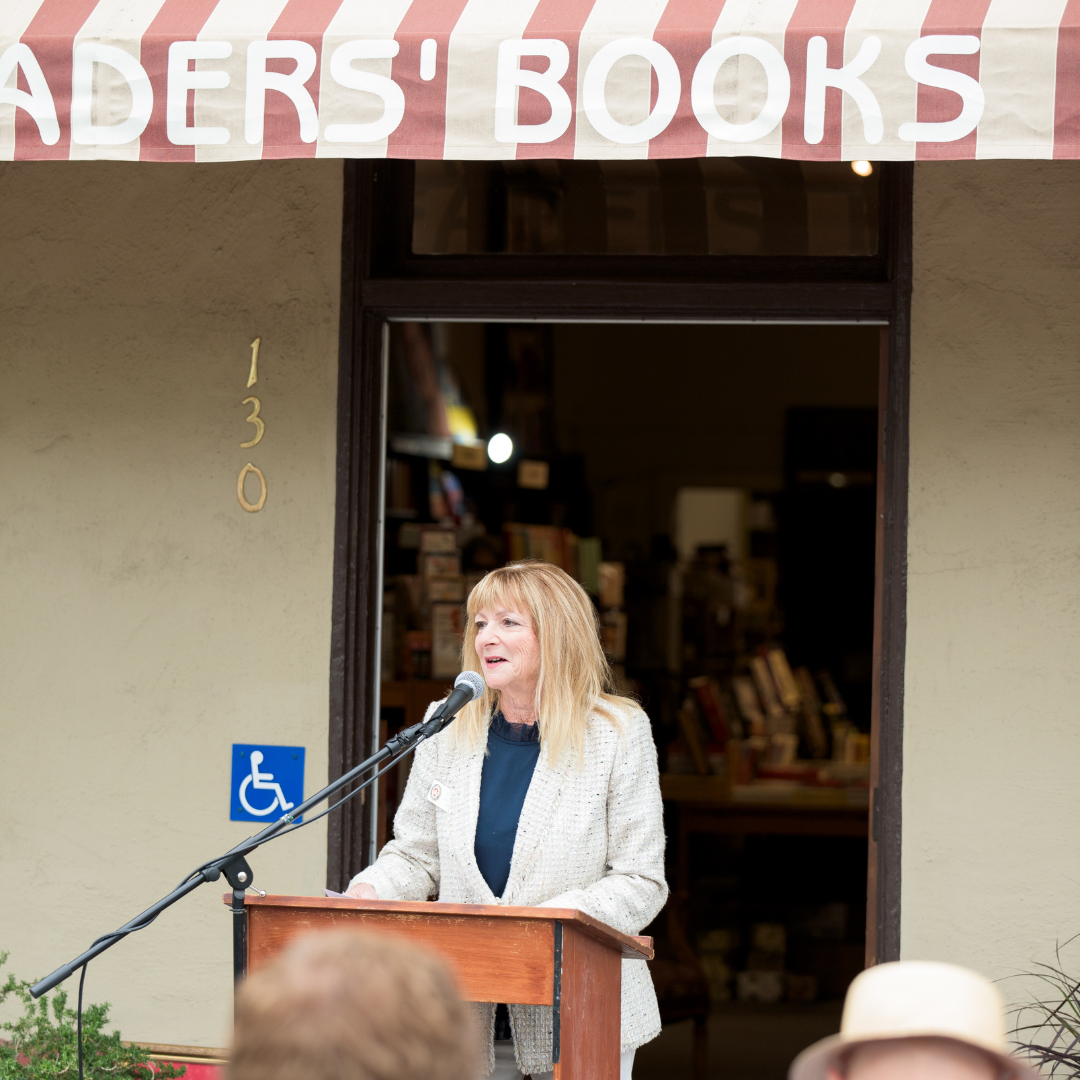 Mayor Sandra Lowe at a podium in front of Readers' Books.