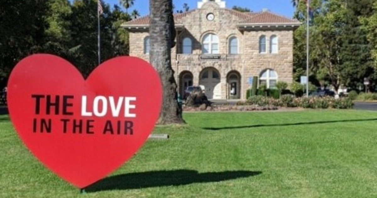 A large heart sculpture on a lawn in front of Sonoma City Hall that says "The Love in the Air."