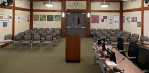 A photo of Sonoma City Council Chambers from the perspective of the Dias, looking out onto a display of artwork on the walls.