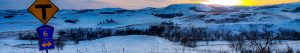 County Road 6 sign in the snow at sunset