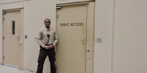 Male Corrections Deputy outside of the Public Access door to the Correctional Center