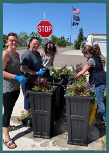 Four women planting flowers