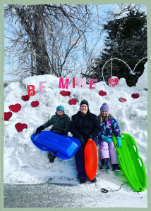 A woman and two children with sleds